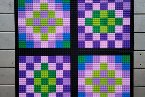A brick quilt pattern made with purple, green, pink and blue colors