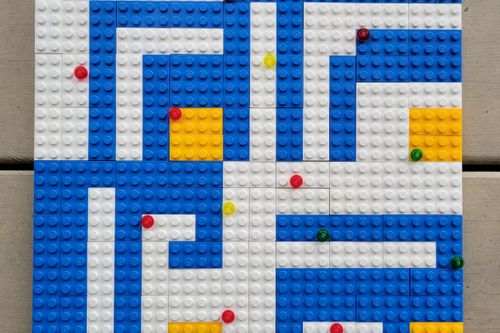 Square pattern design using white, red, blue. and yellow bricks