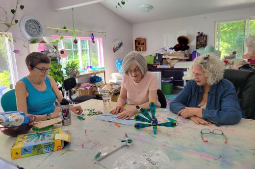 Three people creating with bricks inside a home