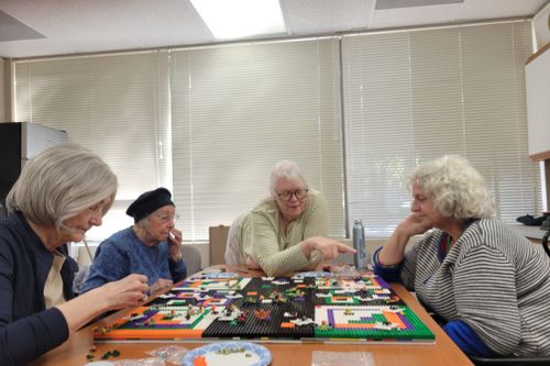 Four seniors spending time in community and creating with bricks