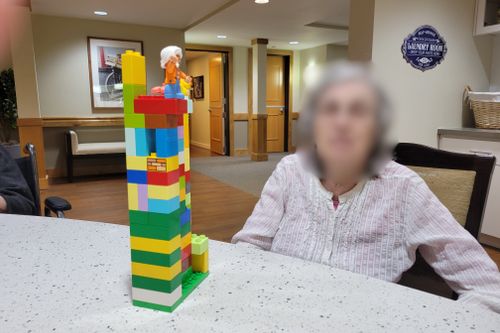 Blurred senior showing their colorful DUPLO® stacked tower